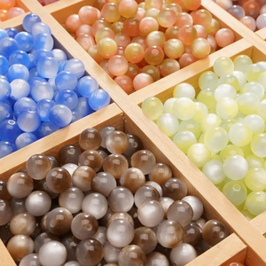 Detailed view of colorful cat-eye resin beads in a wooden box for DIY jewelry making