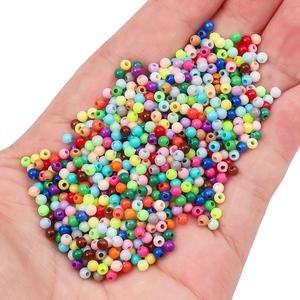 Colorful 3mm acrylic round beads for DIY handmade jewelry held in a person's palm
