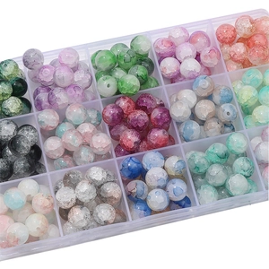 Macro detail of crackle glass beads sorted by colors in a clear storage organizer box