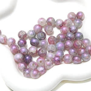 Détail macro de perles en verre violet aurora au fini métallique pour bijoux DIY