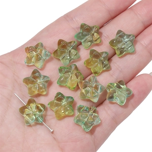 Star-shaped gradient glass beads for DIY jewelry making shown on hand for scale