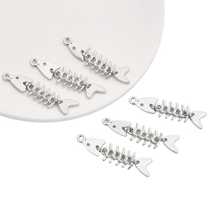 Vue macro de cinq breloques en forme d'arête de poisson argentées pour bijoux DIY