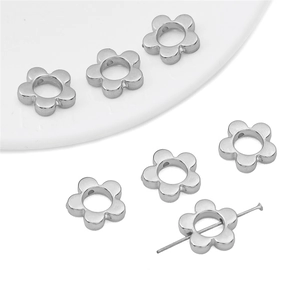 Macro detail of silver flower beads for DIY jewelry making with smooth metallic finish