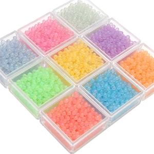 Vue détaillée de perles lumineuses en verre coloré dans neuf compartiments de rangement