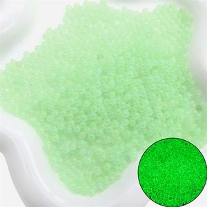 Perles en verre lumineuses avec un effet fluorescent vert brillant dans le noir