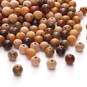 Variety of natural round wood beads in assorted colors and textures for DIY jewelry making