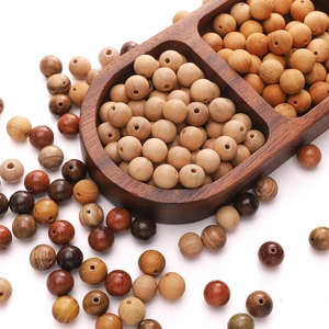 Close-up of polished natural wood beads with organic textures in a divided wooden tray