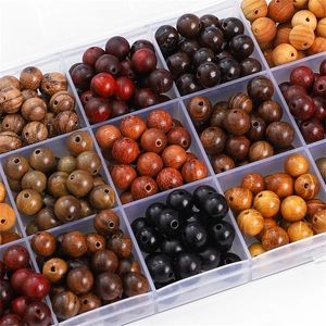 Top view of natural wood beads in various textures and colors within a clear grid box