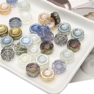 Detailed macro view of faceted glass aurora beads for handmade jewelry in a ceramic plate