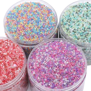 Close-up of four jars containing colorful 2.5mm glass seed beads for DIY jewelry making