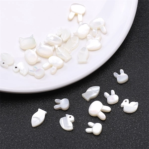 Macro detail of white mother-of-pearl animal charms for DIY jewelry making