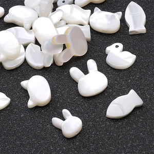 Macro detail of animal-shaped white mother of pearl shell beads for jewelry making