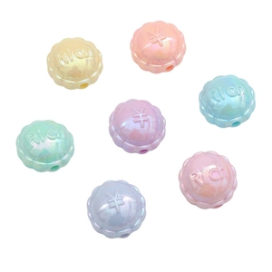 Vue macro de perles acryliques colorées avec revêtement iridescent et motifs en relief