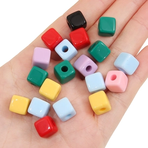Close-up of colorful acrylic cube beads for DIY jewelry making held in a palm