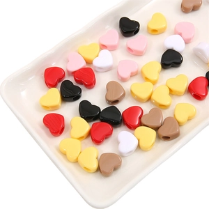 Perles colorées en acrylique en forme de cœur pour colliers DIY dans un plateau blanc
