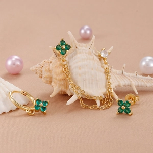Gold stainless steel earring set featuring emerald clover studs and tassel chain cuff