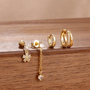 Detalle del juego de 4 pendientes de latón dorado con colgante de flor y circonitas