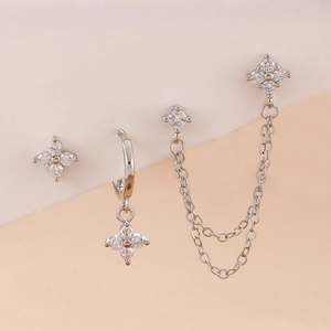 Macro shot of silver stainless steel earring set with floral zircon studs and chain link details