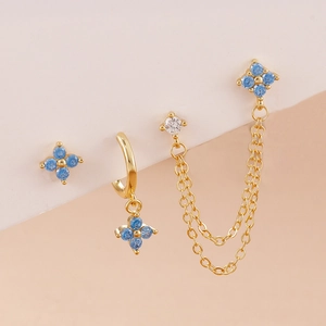 Detail of gold-plated petal earrings set with deep blue gems and elegant chain tassels