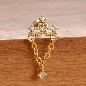 Detalle de pendiente corona dorada con cadenas colgantes y piedra de ópalo brillante
