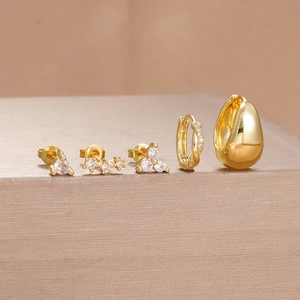 Macro detail of 5-piece gold-plated earring set featuring zircon studs and chunky hoops