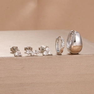 Macro detail of a 5-piece silver S925 earring set featuring cubic zirconia studs and hoops