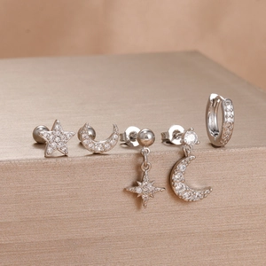 Detailed set of star and moon earrings with cubic zirconia stones on gold stand