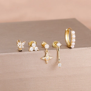Detailed set of five gold earrings with sparkling zircons and elegant pearls