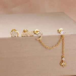 Macro shot of gold celestial earrings set featuring moon and star zircon details