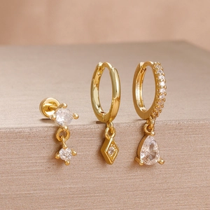 Detailed macro of three-piece gold stainless steel earring set with sparkling zircons