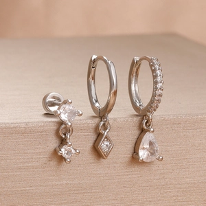 Macro detail of three-piece silver stainless steel earrings set with zircon stones