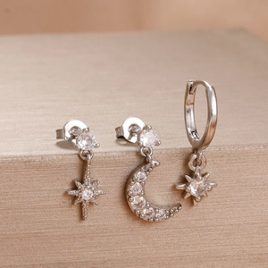 Detail of three-piece silver star and moon earrings set with sparkling zircon stones