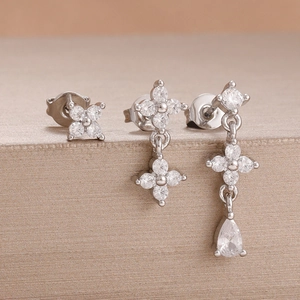 Detailansicht eines silbernen Blumenohrring-Sets mit glänzenden Zirkonia-Steinen