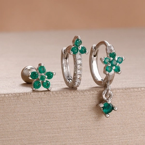 Makrodetail eines dreiteiligen Silber-Ohrring-Sets mit leuchtend grünen Zirkonia-Steinen