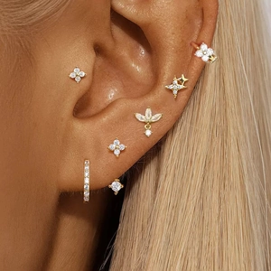 Schickes goldenes Piercing-Ohrring-Set mit Zirkonia-Steinen am Ohr eines weiblichen Models