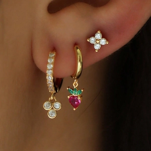 Détail de boucles d'oreilles serpent de luxe avec forme d'étoile et breloques fraise