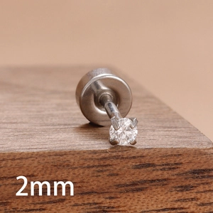 Macro d'un clou d'oreille en zircon de 2mm avec serti à quatre griffes sur bois