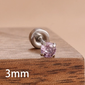 Détail macro d'un clou d'oreille en zircon rose de 3mm avec serti à quatre griffes en acier
