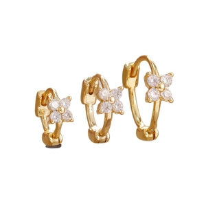 Trois tailles de créoles fleurs dorées de luxe avec diamants étincelants sur fond blanc
