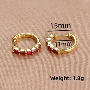 Détail de boucles d'oreilles dorées de 15mm avec zircons rouges et poinçon S925