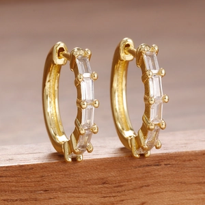 Élégantes boucles d'oreilles créoles dorées avec zircons rectangulaires et sertissage