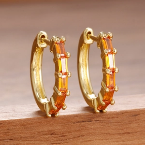 Boucles d'oreilles créoles dorées serties de zircons orange taille baguette