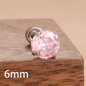 Détail macro d'un clou d'oreille zircon rose 6mm avec serti à quatre griffes sur bois