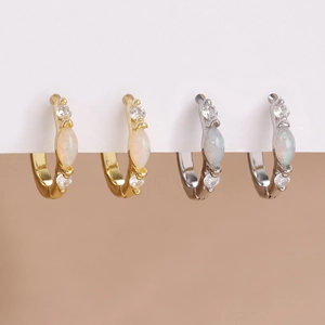 Detailed close-up of gold and silver hoop earrings featuring marquise opal and zircon studs
