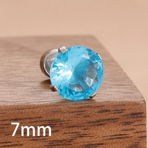 Gros plan détaillé du clou d'oreille en zircon bleu de 7 mm avec monture argentée à griffes