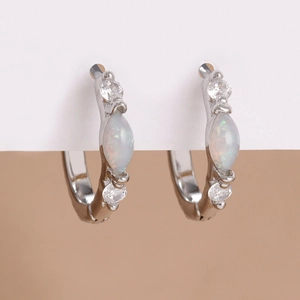 Close-up of silver earrings with center opal stone and micro-set cubic zirconia accents