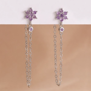 Dettaglio di orecchini d'argento con fiore di zircone viola e catena a nappa fine
