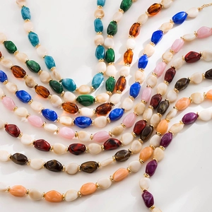 Dettaglio delle perle in resina colorata e distanziatori dorati sulla collana