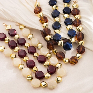 Detail of colorful resin beaded necklaces with large hexagonal beads and gold accents