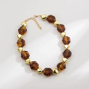 Detail of amber faceted beads and gold irregular geometric metal spacers on a necklace
